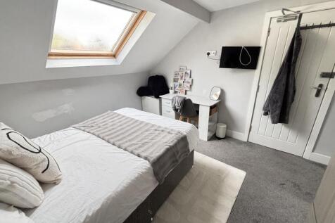 A bright and spacious master bedroom with a lar...