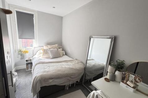 A bright, well-maintained double bedroom with a...