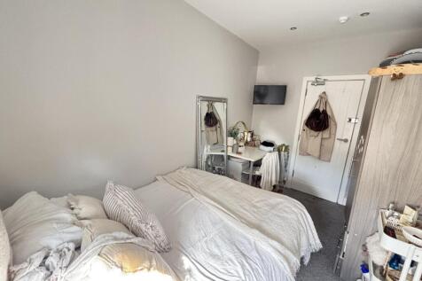 A bright and inviting bedroom featuring a comfo...