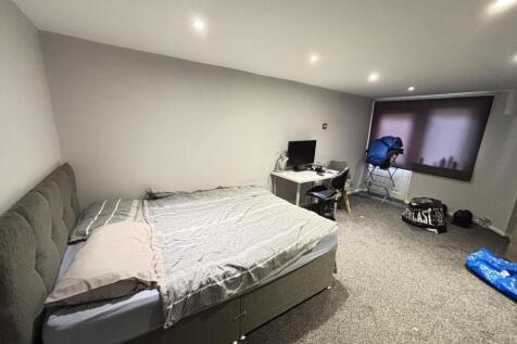 A spacious master bedroom featuring a large bed...