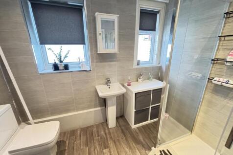 A clean and bright bathroom with a modern showe...
