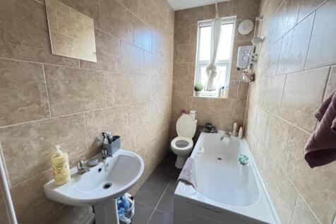 A well-maintained bathroom with a large bathtub...