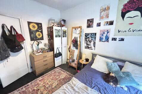 A cozy bedroom featuring a bed with pillows and...