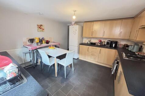 A bright and modern kitchen area with ample woo...