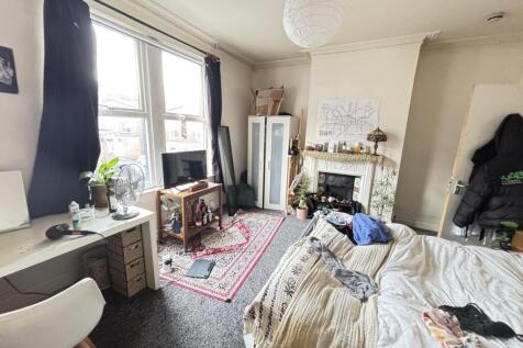 A cozy bedroom featuring a large window with na...