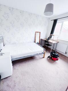 Bright, simply furnished bedroom with a double ...