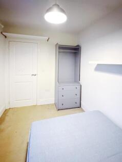 Bright, simply furnished bedroom with a built-i...