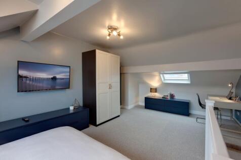 Bright and spacious master bedroom featuring a ...