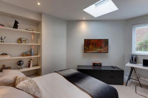 A bright and modern bedroom featuring a comfort...