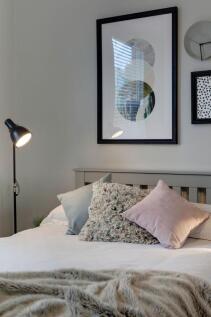 A bright, well-maintained master bedroom featur...