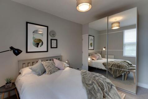 A spacious and stylish master bedroom featuring...