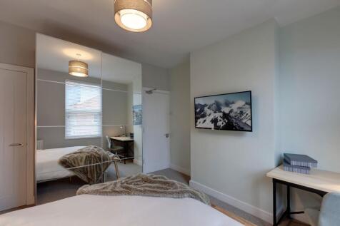 A well-lit and inviting bedroom featuring a lar...