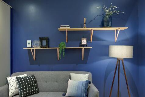 Charming living room featuring a vibrant blue a...