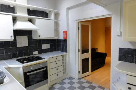 A well-maintained kitchen with black tiled back...