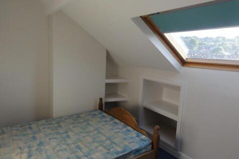 Bright and cozy bedroom with a sloped ceiling, ...