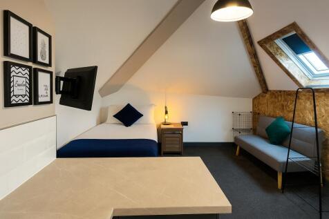 A modern, well-lit spacious bedroom with a comf...