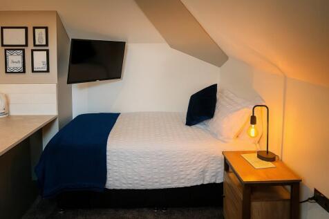 A cozy double bedroom featuring a neatly made b...