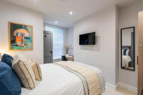 A bright and modern master bedroom featuring a ...
