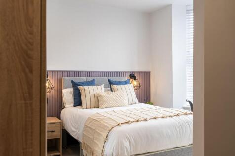 A spacious, elegantly decorated bedroom featuri...