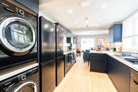 Modern, bright kitchen equipped with sleek dark...