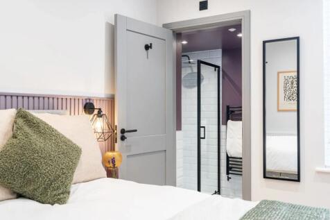 A stylish and comfortable master bedroom featur...