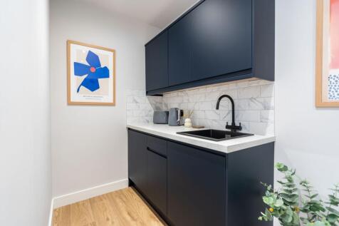 Modern kitchen featuring sleek navy blue cabine...
