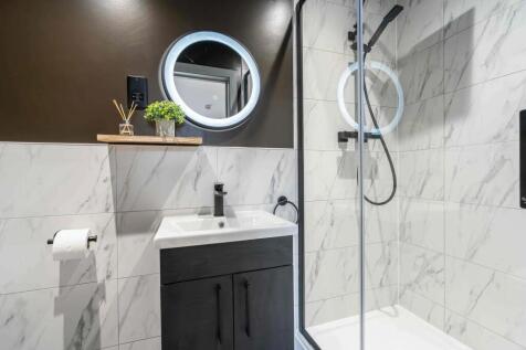 Modern and sleek bathroom featuring a walk-in s...