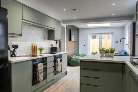Modern and stylish kitchen featuring sleek gree...