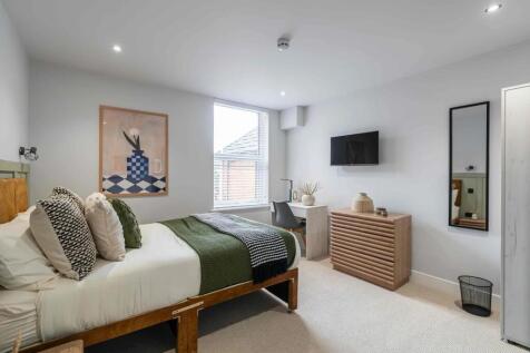 Bright and welcoming master bedroom featuring a...