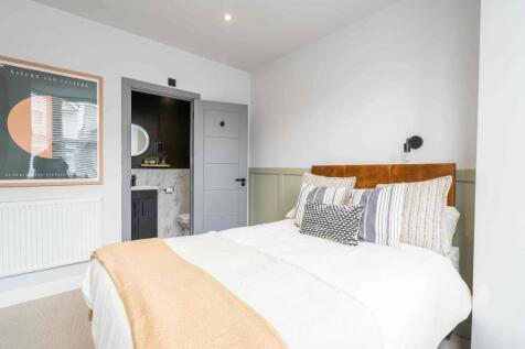 Bright and inviting bedroom featuring a cozy be...