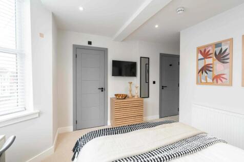 Bright and modern master bedroom featuring a sp...