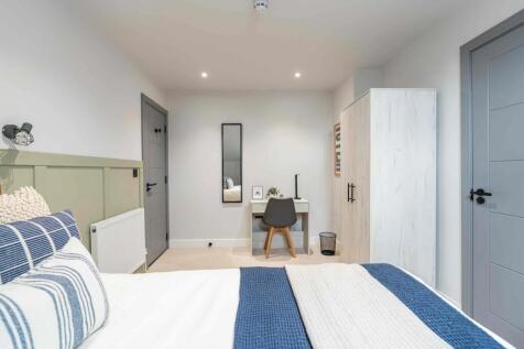 Bright and modern master bedroom featuring a do...