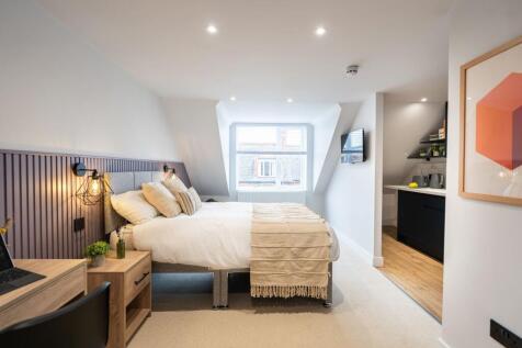 A modern, well-lit bedroom featuring a large be...