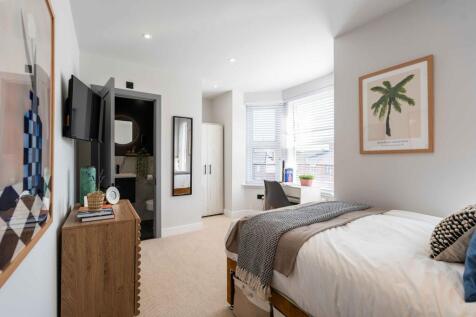 A bright, well-maintained bedroom featuring a c...