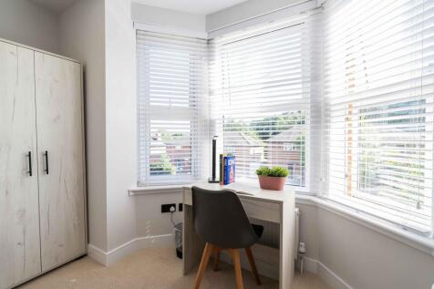 Bright and airy bedroom featuring large windows...