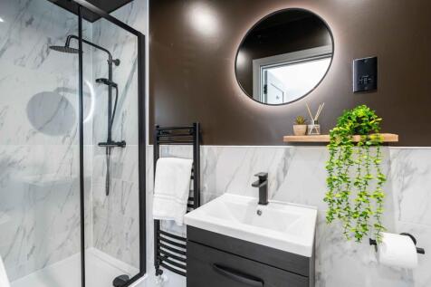 Modern bathroom featuring a sleek shower with g...