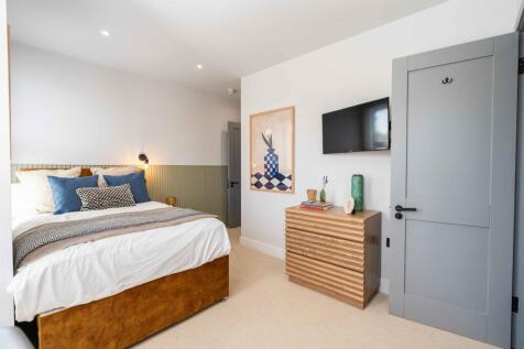 Bright and stylish master bedroom featuring a c...