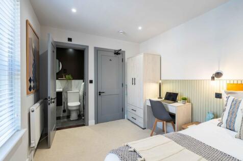 A modern and well-lit student bedroom featuring...