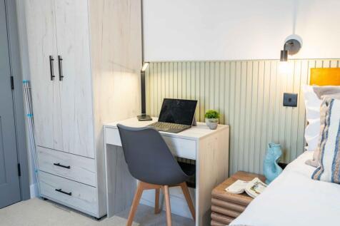 A cozy bedroom with a neatly made bed, a compac...