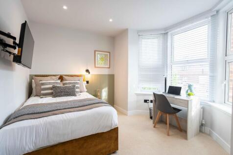 Bright and inviting master bedroom with a comfo...
