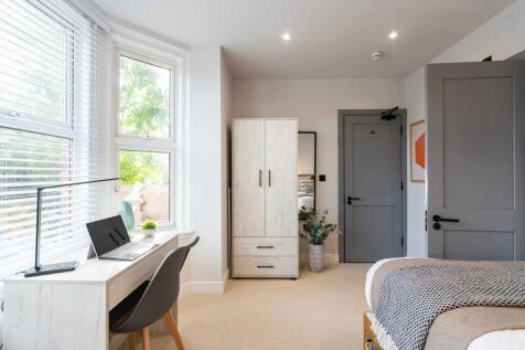 Bright and welcoming double bedroom featuring a...