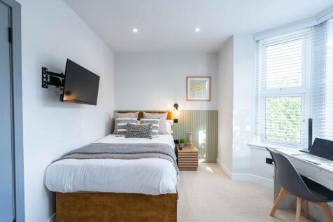 Bright and welcoming bedroom featuring a comfor...