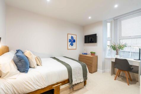 Bright and welcoming bedroom featuring a comfor...
