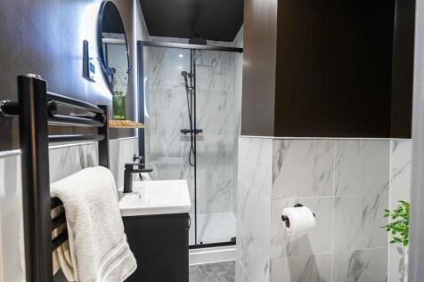 Modern and stylish bathroom featuring white mar...