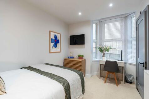 Bright and welcoming master bedroom featuring a...