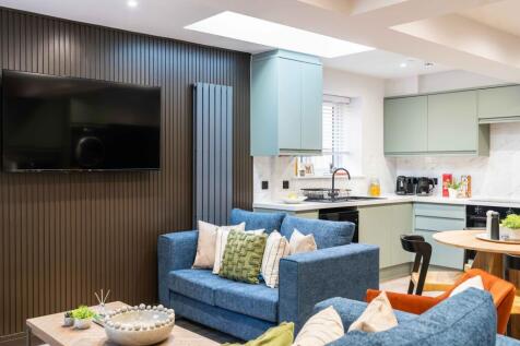 A modern, well-lit living room featuring a larg...