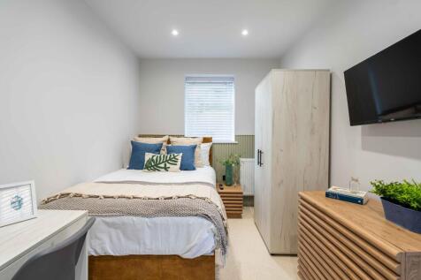 A bright and inviting master bedroom featuring ...