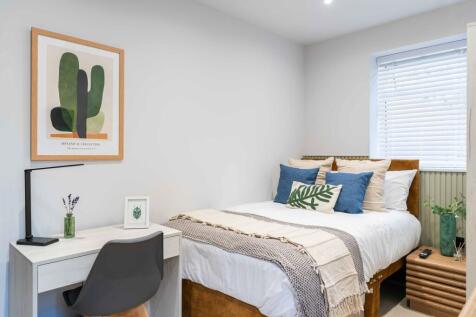 A bright, inviting double bedroom featuring a c...