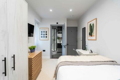 Bright and modern master bedroom featuring ampl...