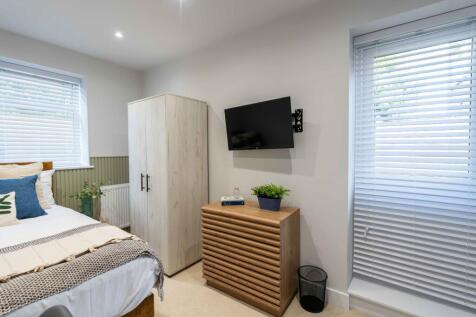 A bright and inviting bedroom featuring a well-...